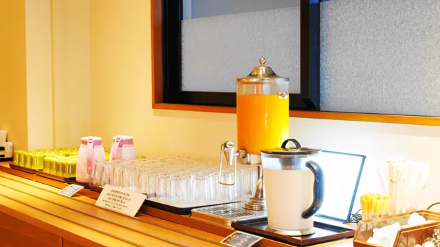 オレンジジュースのディスペンサーと乳酸菌飲料が並ぶドリンクコーナー