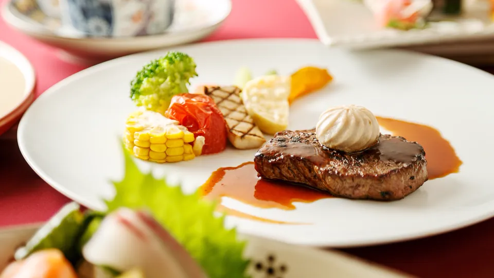 会席「響」の洋皿、牛ヒレステーキ。焼き目のついたお肉に、東温産のとうもろこしやトマトを添えて