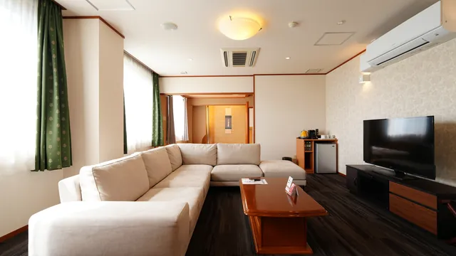 L字ソファと大型テレビを置いたリビングルーム