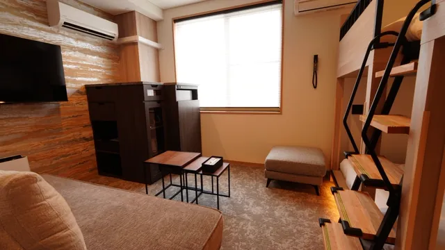 ソファとテレビ、ミニキッチンを備えたくつろぎのスペース