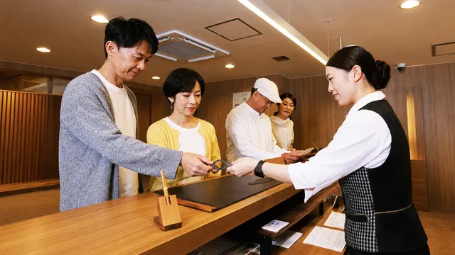 フロントでリストバンドを受け取る宿泊客
